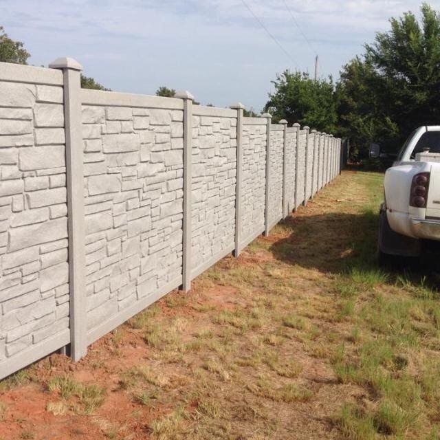 A white truck is parked next to a stone fence