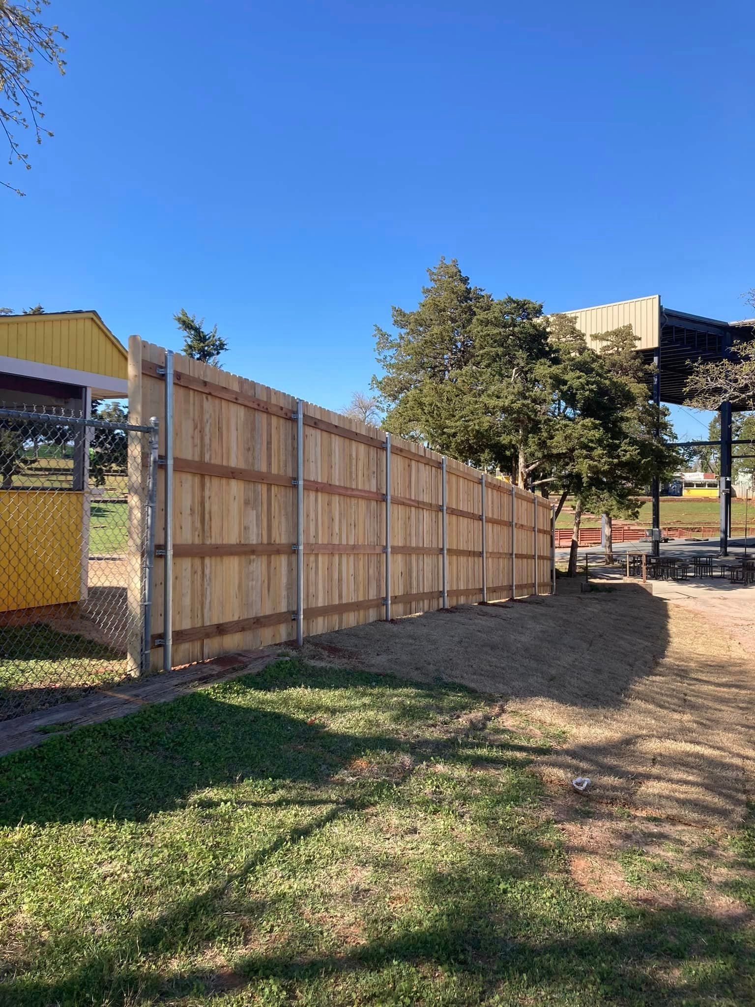 A wooden fence is sitting in the middle of a grassy field.
