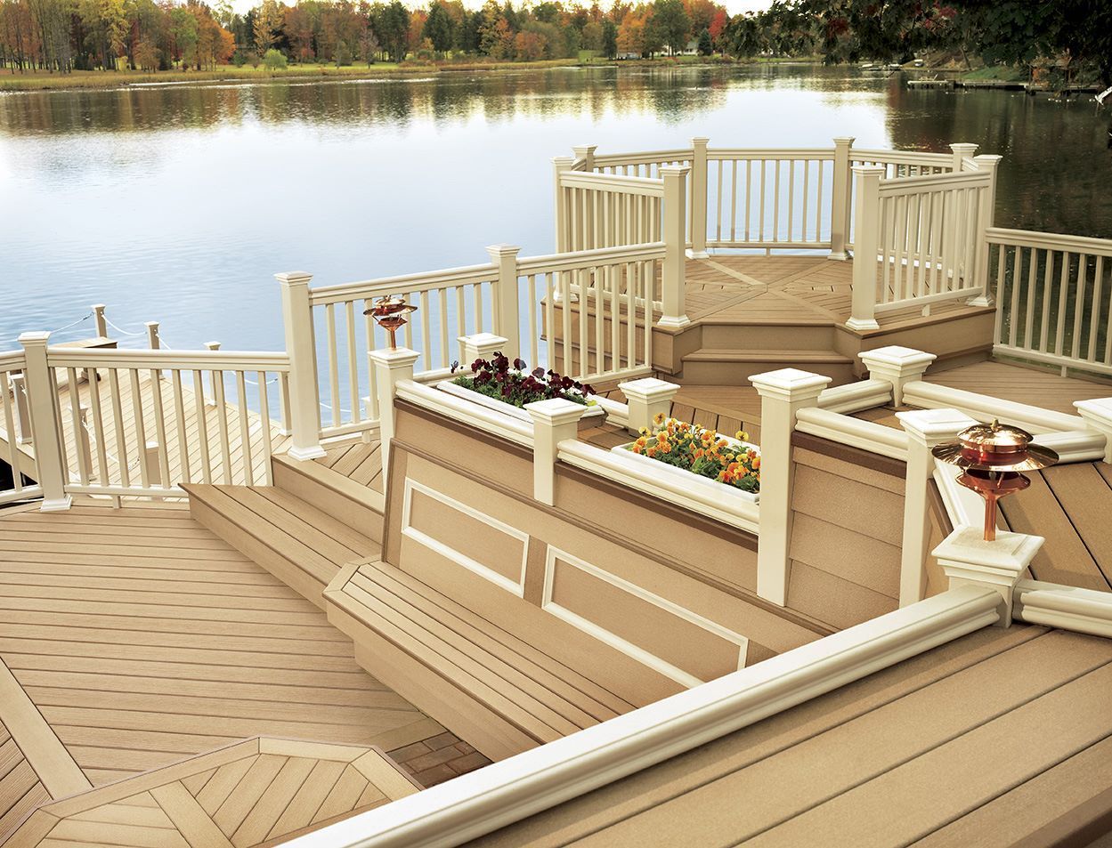 A wooden deck with a white railing overlooking a lake