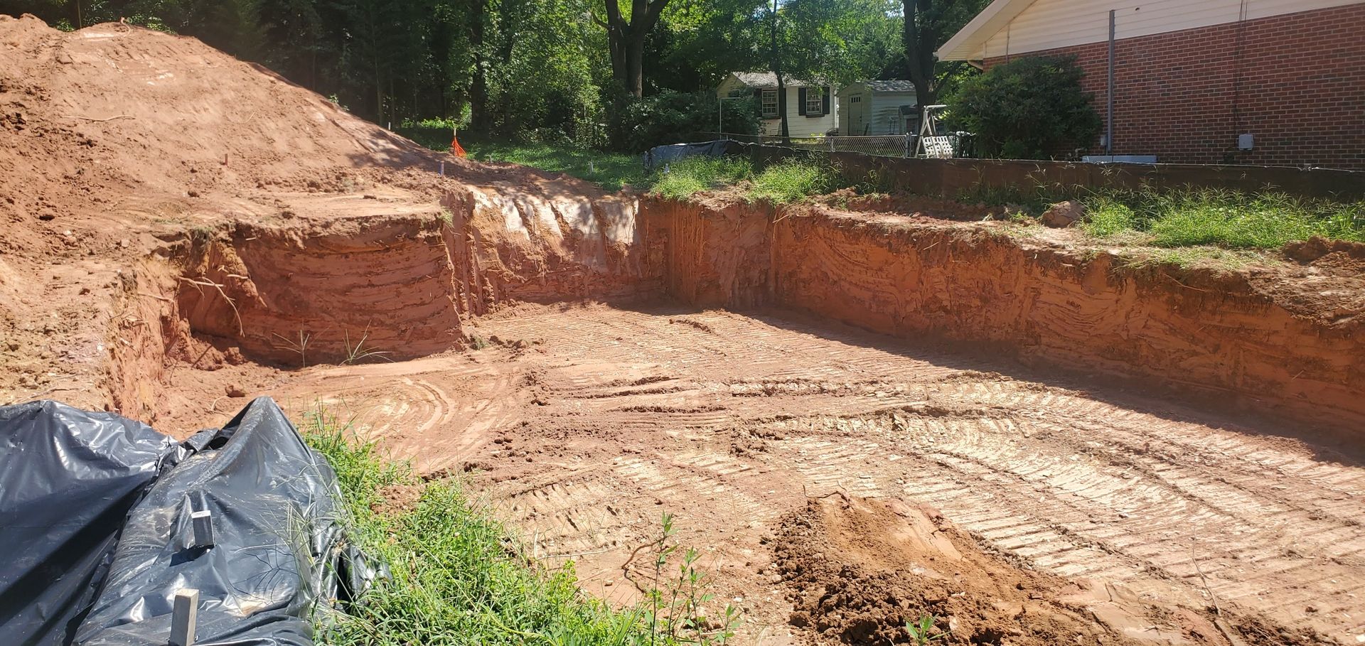A large pile of dirt is sitting in the middle of a dirt road.