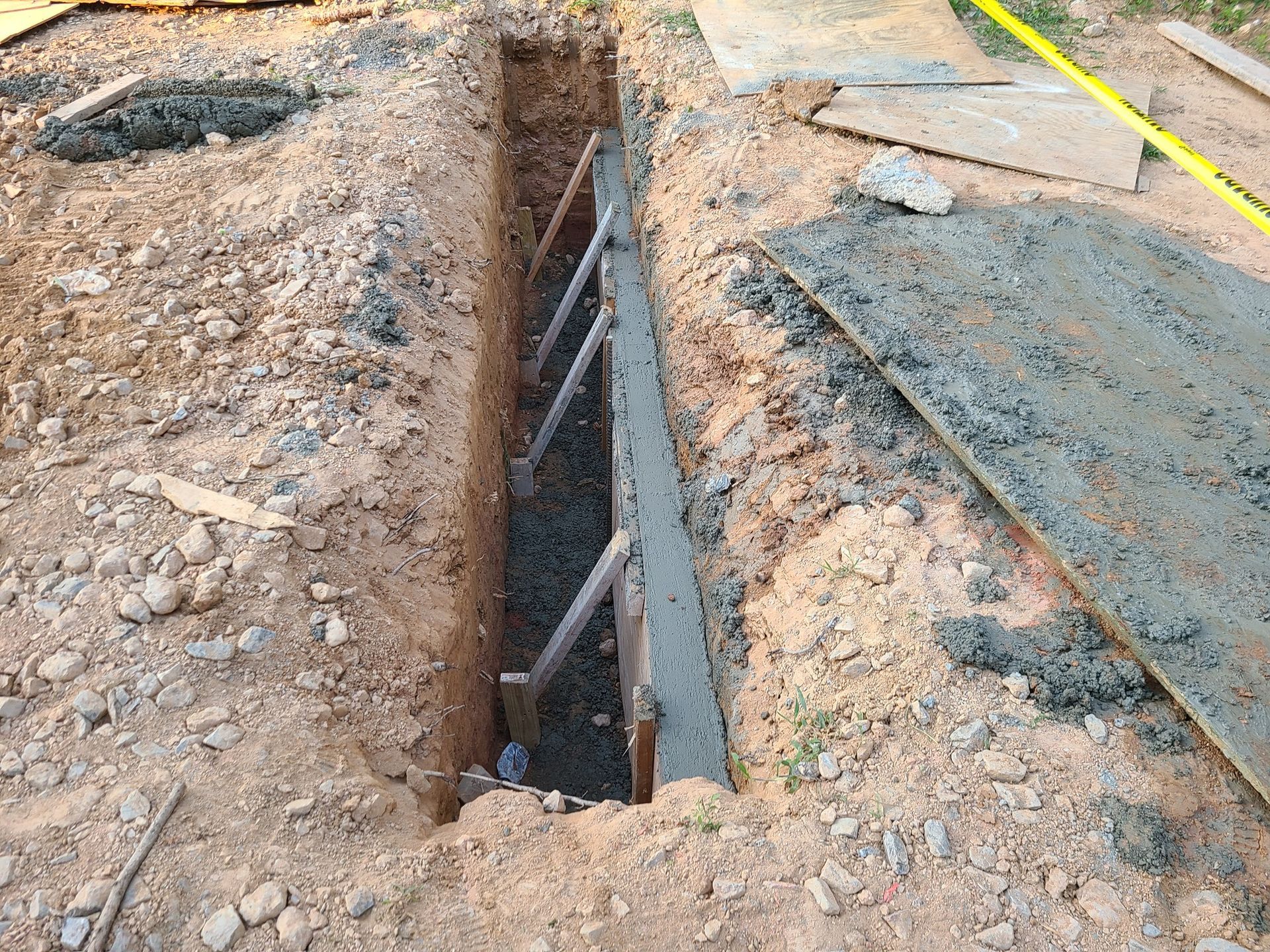 A concrete wall is being built in a hole in the ground.