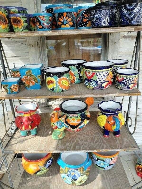 Shelves of colorful hand-painted ceramic pots and bowls displayed outdoors