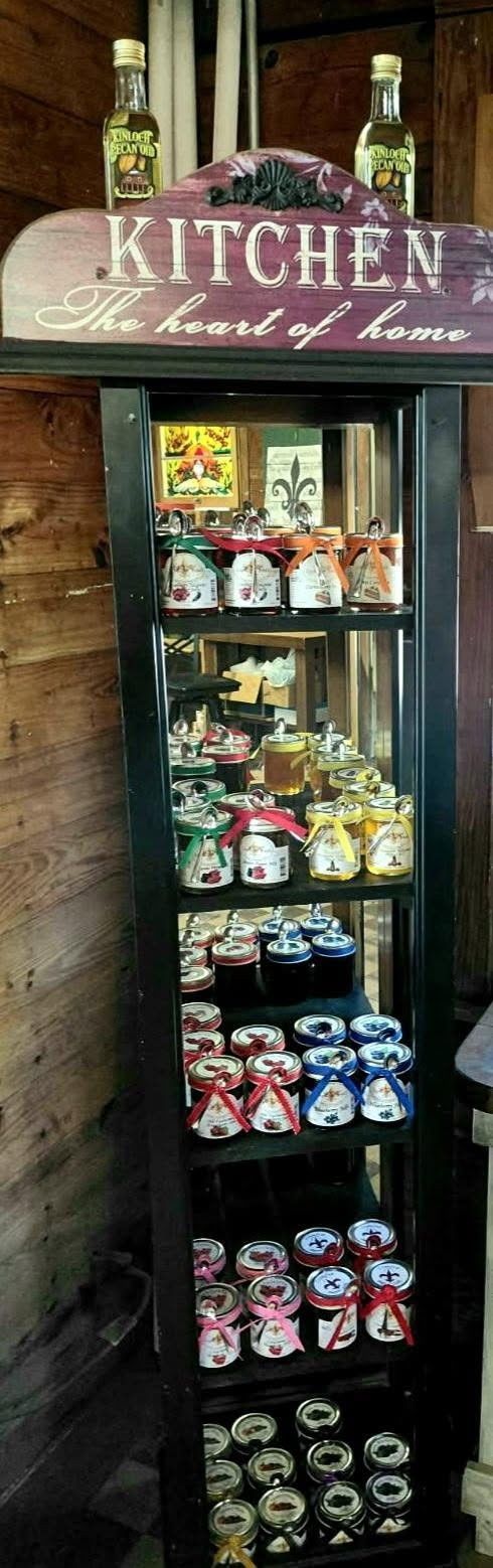 Kitchen sign above a narrow display cabinet filled with colorful packaged goods