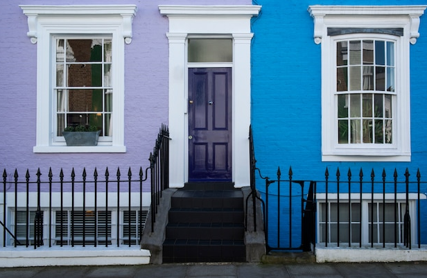 Colorful row houses with a purple door, steps, and matching facades.