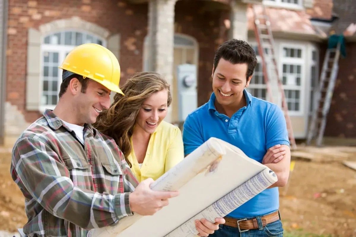 Construction worker showing house plans to a couple, construction site backdrop.
