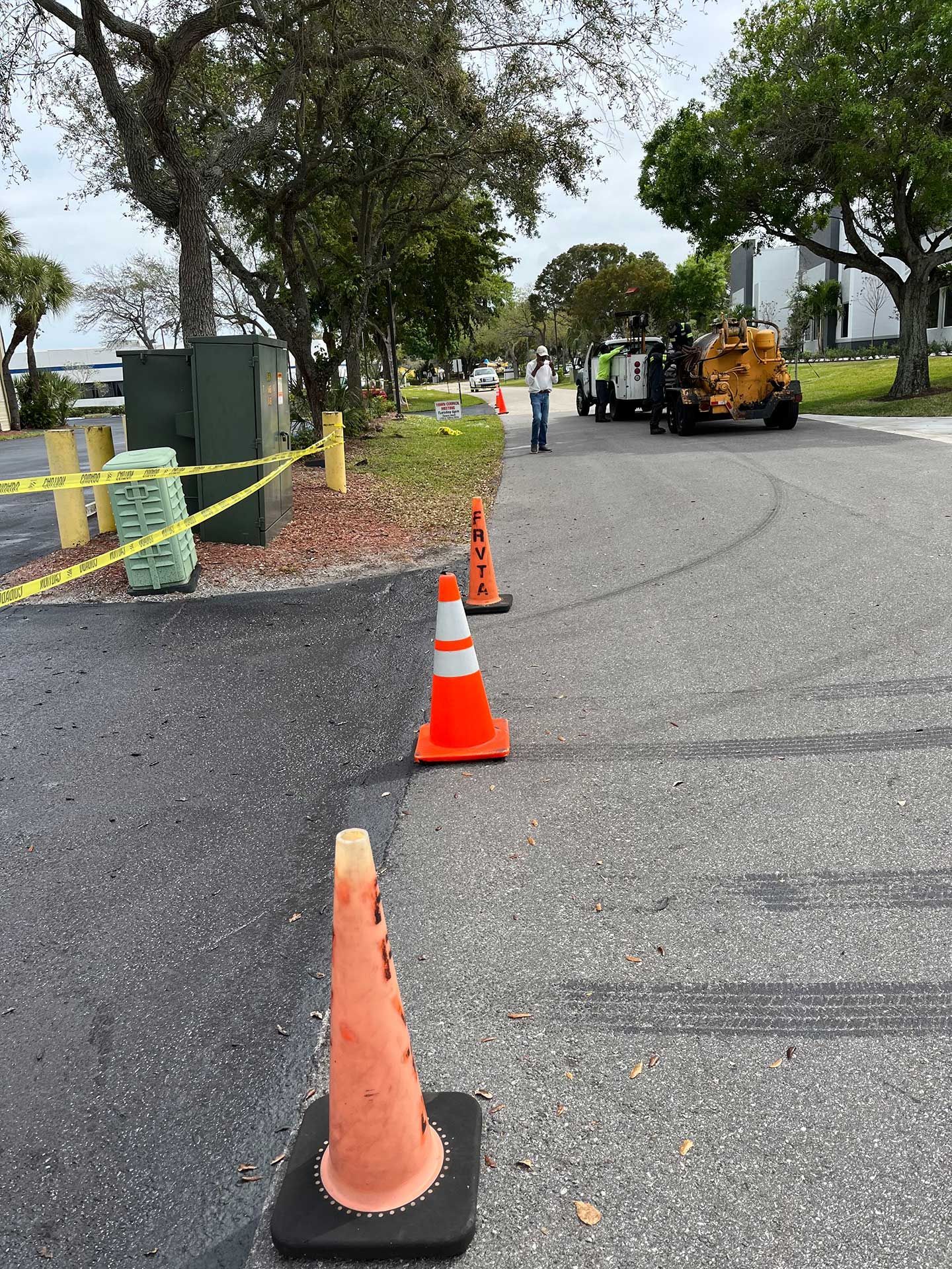 a row of orange and white traffic cones on the side of a road