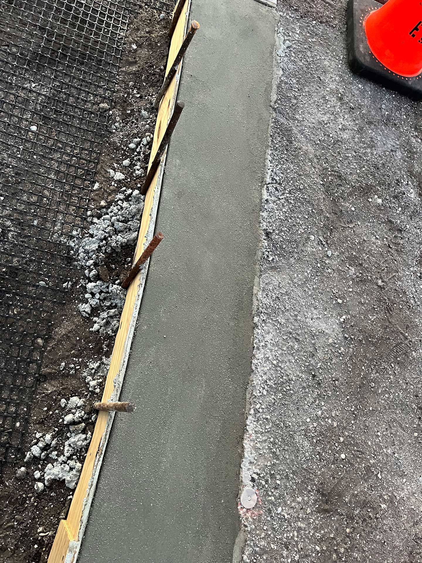 a close up of a concrete curb with a cone in the background