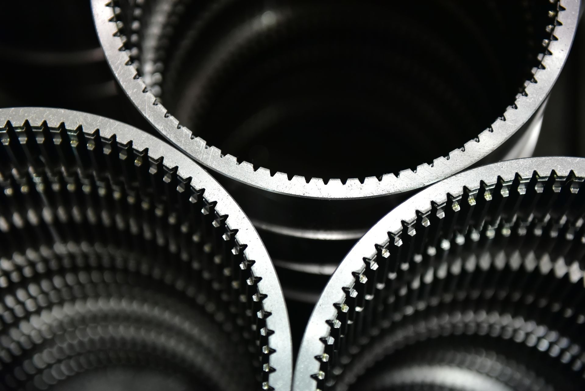 A close up of three belts with a black background
