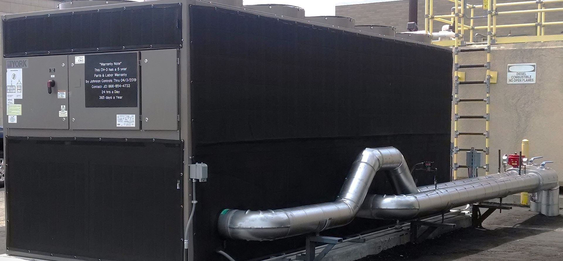 A large black hvac unit with pipes coming out of it