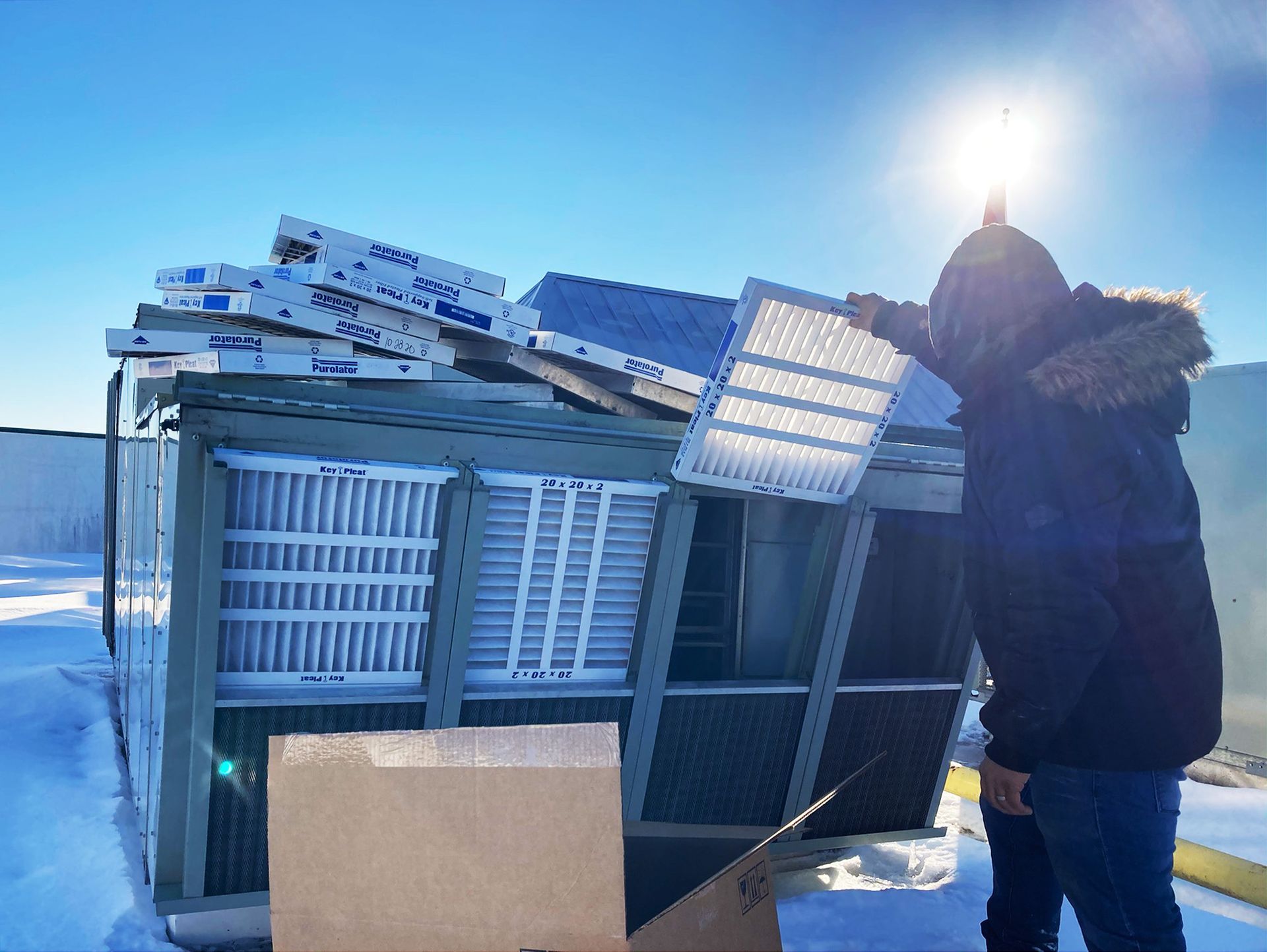 A man is installing new filters on an hvac unit.