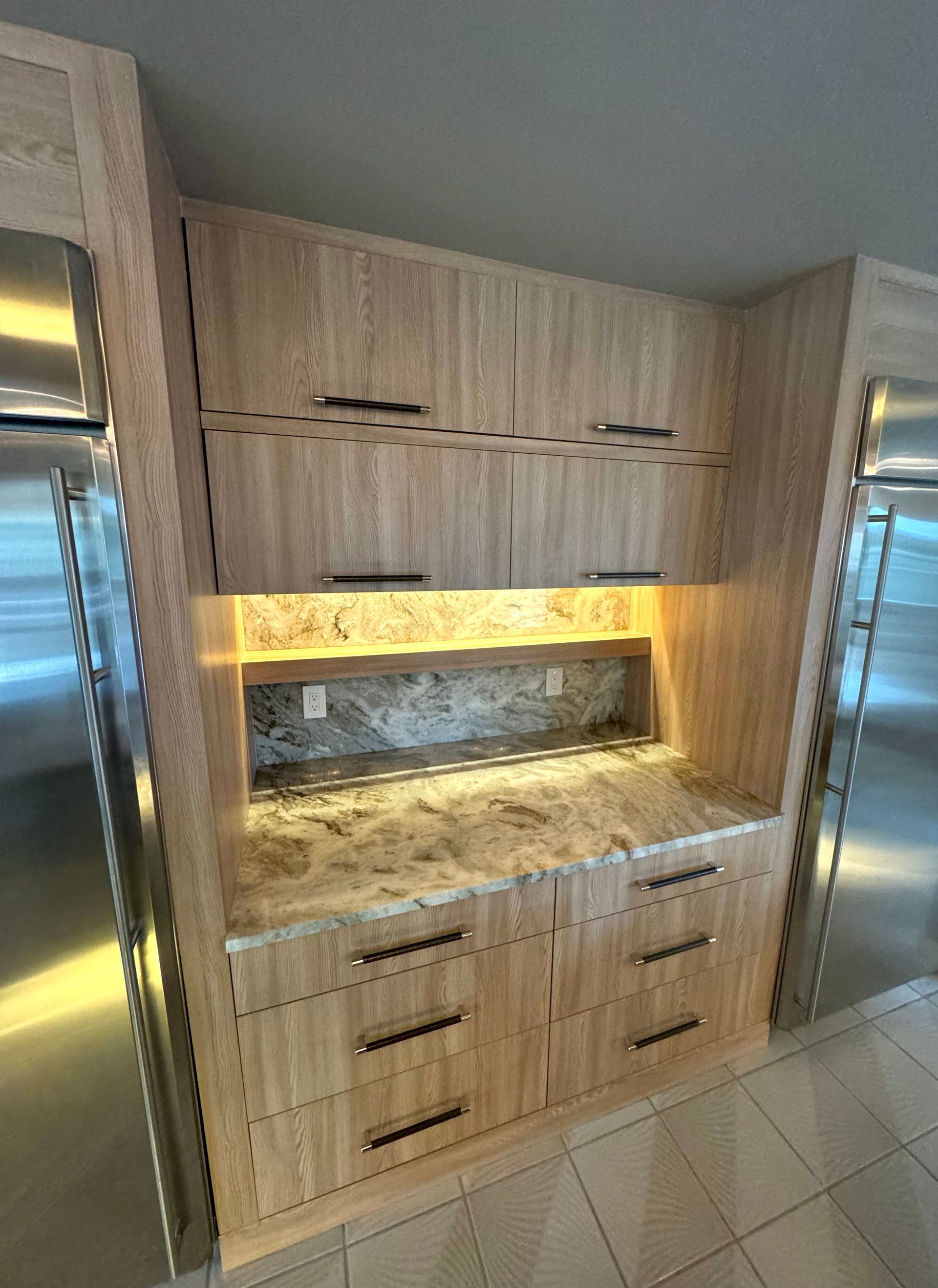 Built-in wood kitchen cabinets with granite countertop and warm under-cabinet lighting