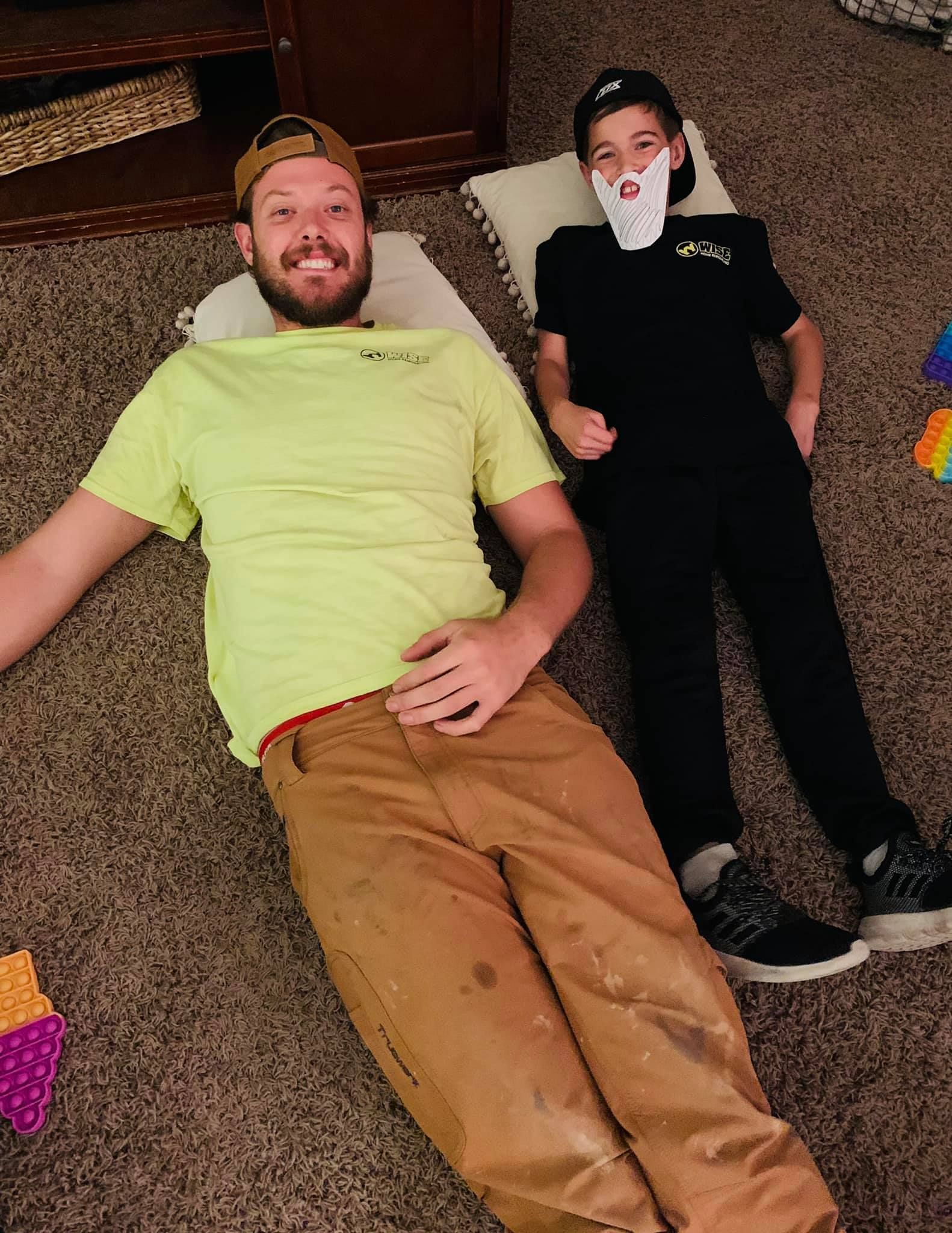 A man and a boy are laying on the floor.
