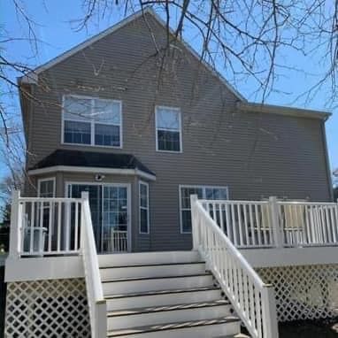A large house with a large deck and stairs leading up to it.