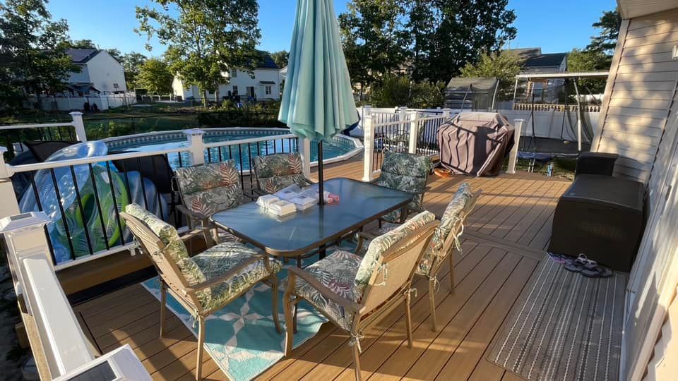 There is a table and chairs on the deck with an umbrella.