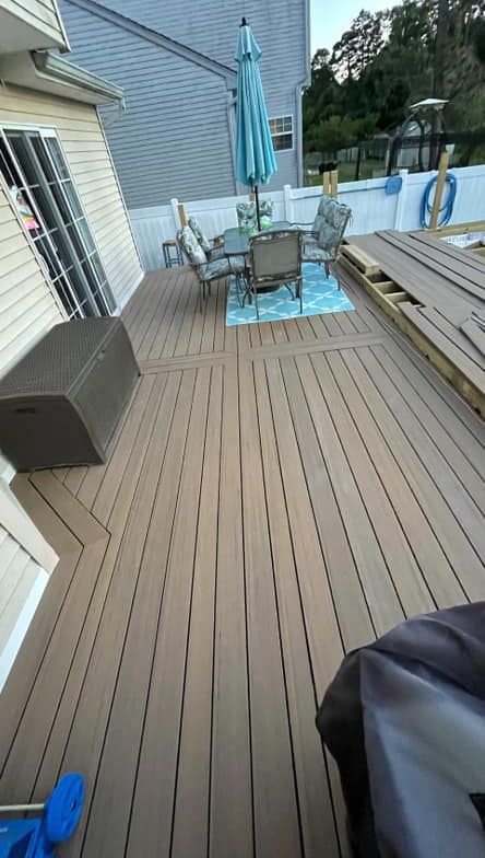 A wooden deck with a table and chairs and an umbrella.