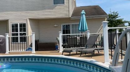 There is a swimming pool in the backyard of a house.