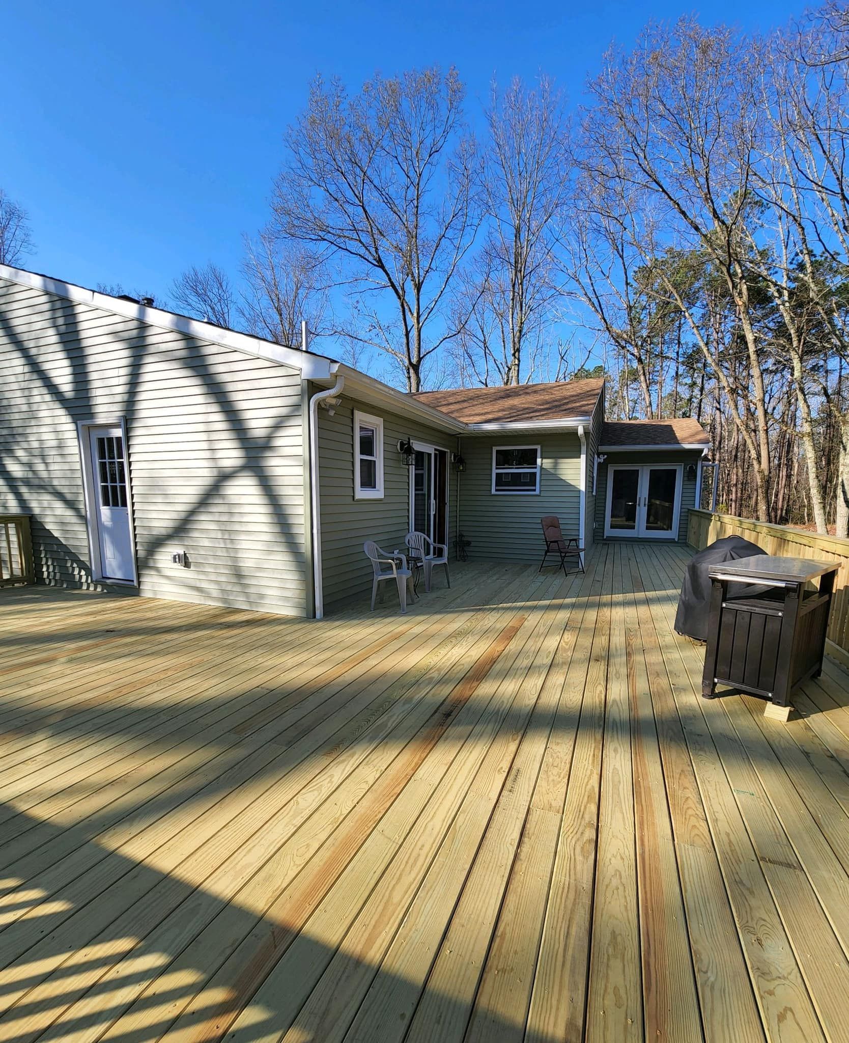 A house with a large wooden deck in front of it.