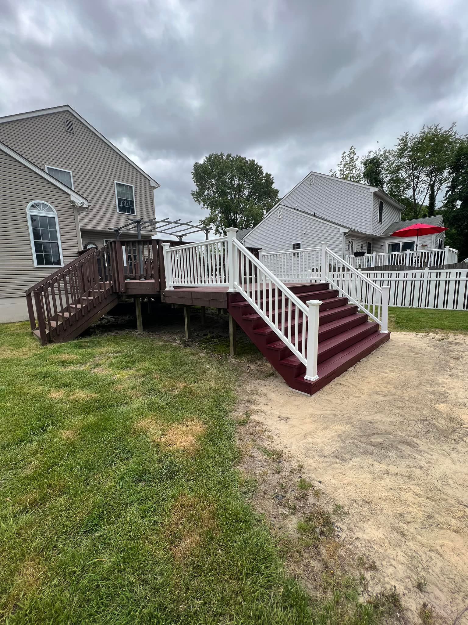 A house with a deck and stairs in front of it.