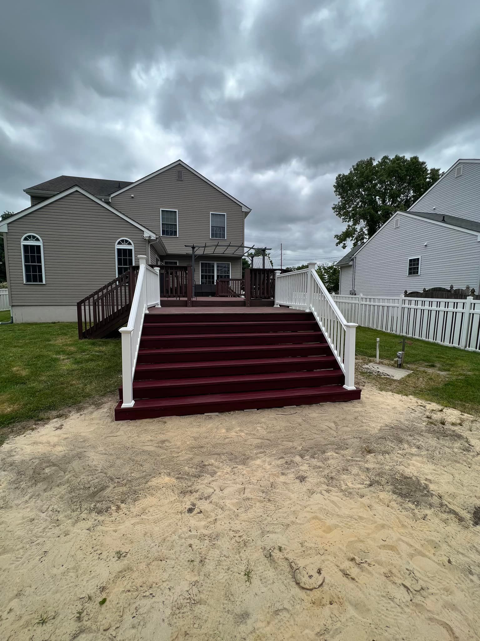 A house with a deck and stairs in front of it.