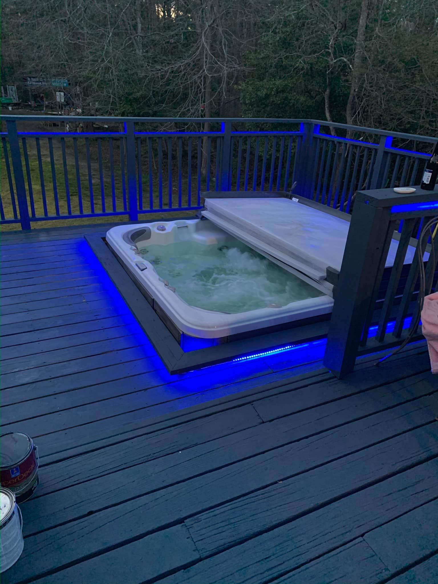 A hot tub is sitting on top of a wooden deck.