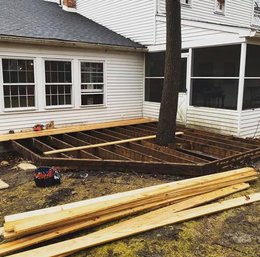A wooden deck is being built in front of a house.