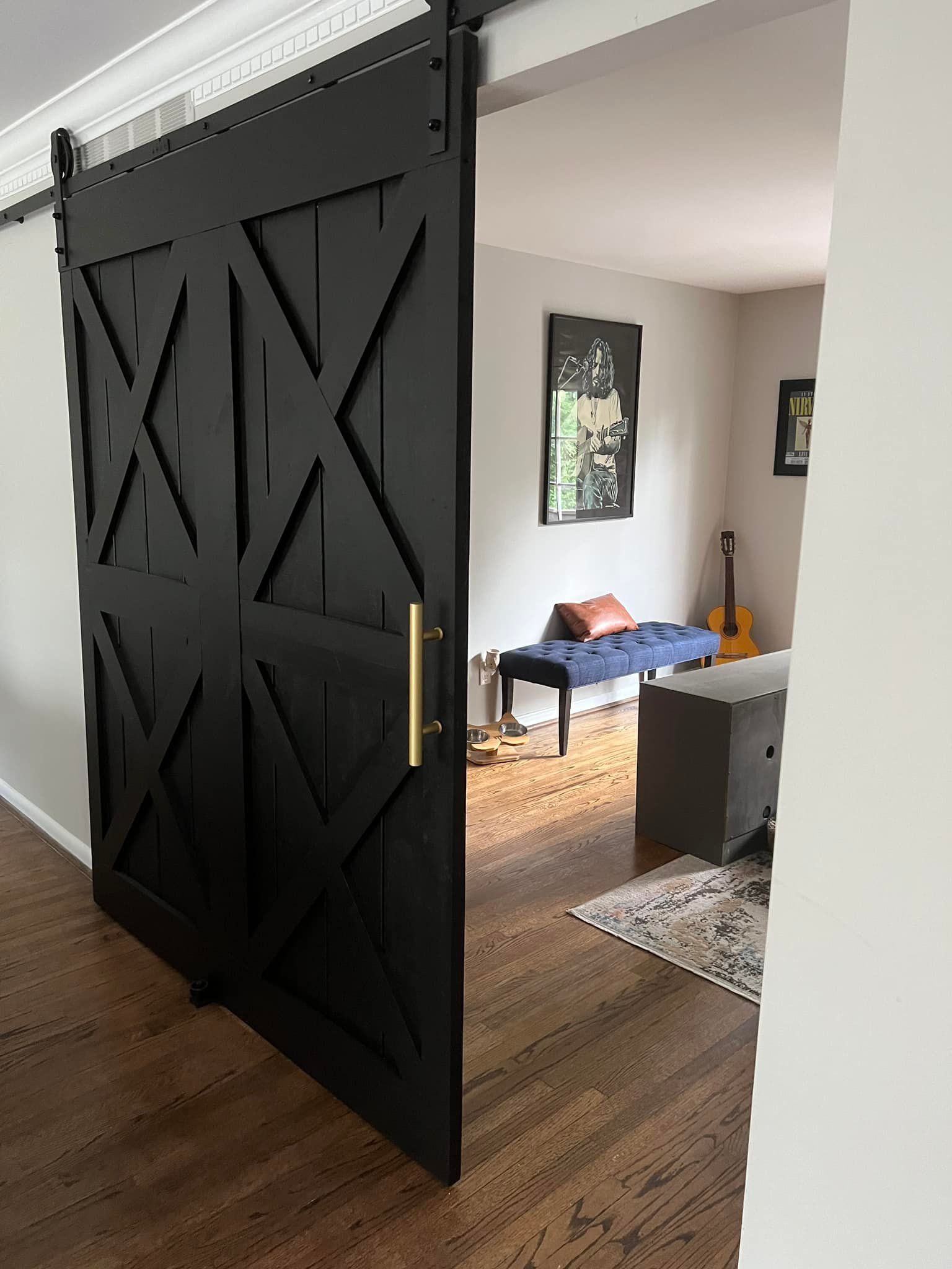 A black sliding barn door is open to a living room.
