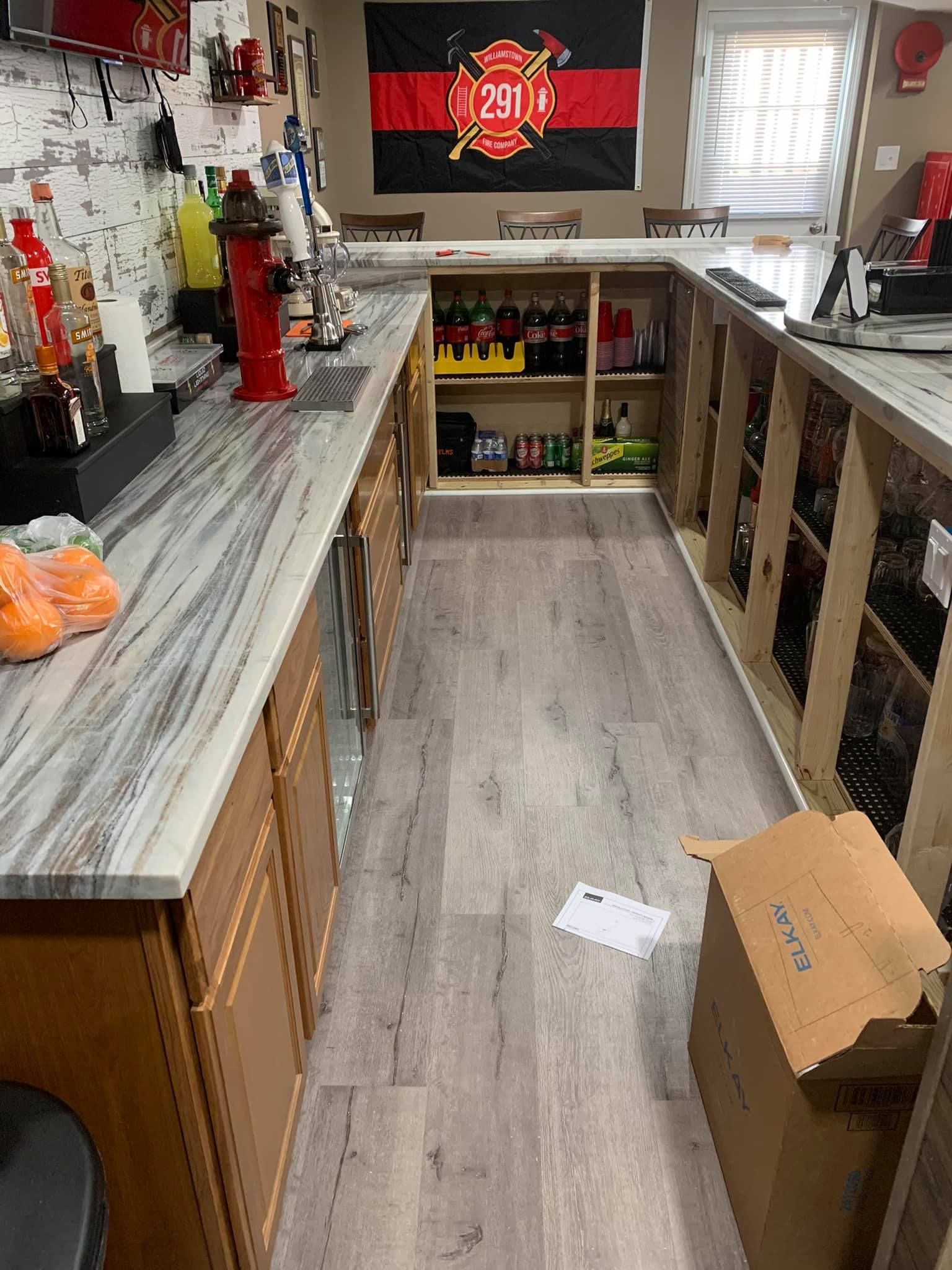 A long kitchen with a lot of cabinets and a box on the floor.