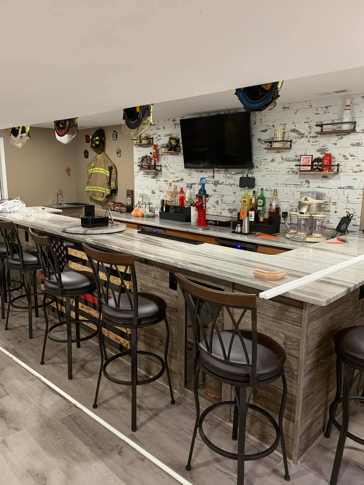 A long bar with stools and a fireman in the background.