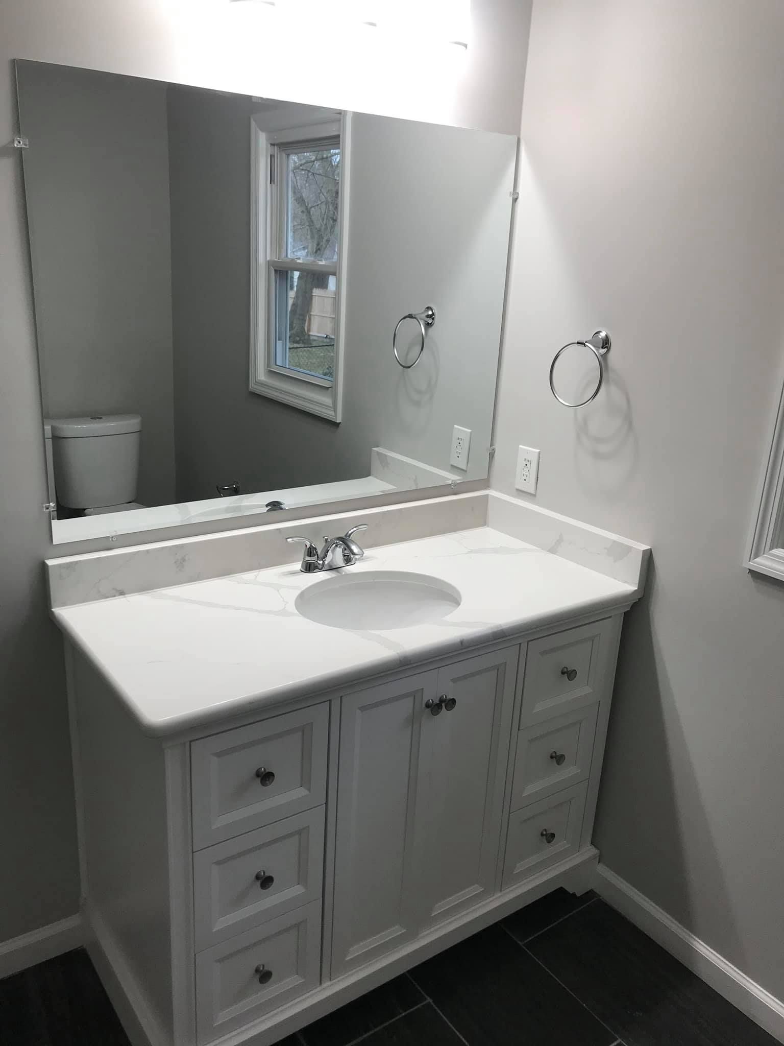 A bathroom with a sink , mirror and toilet.