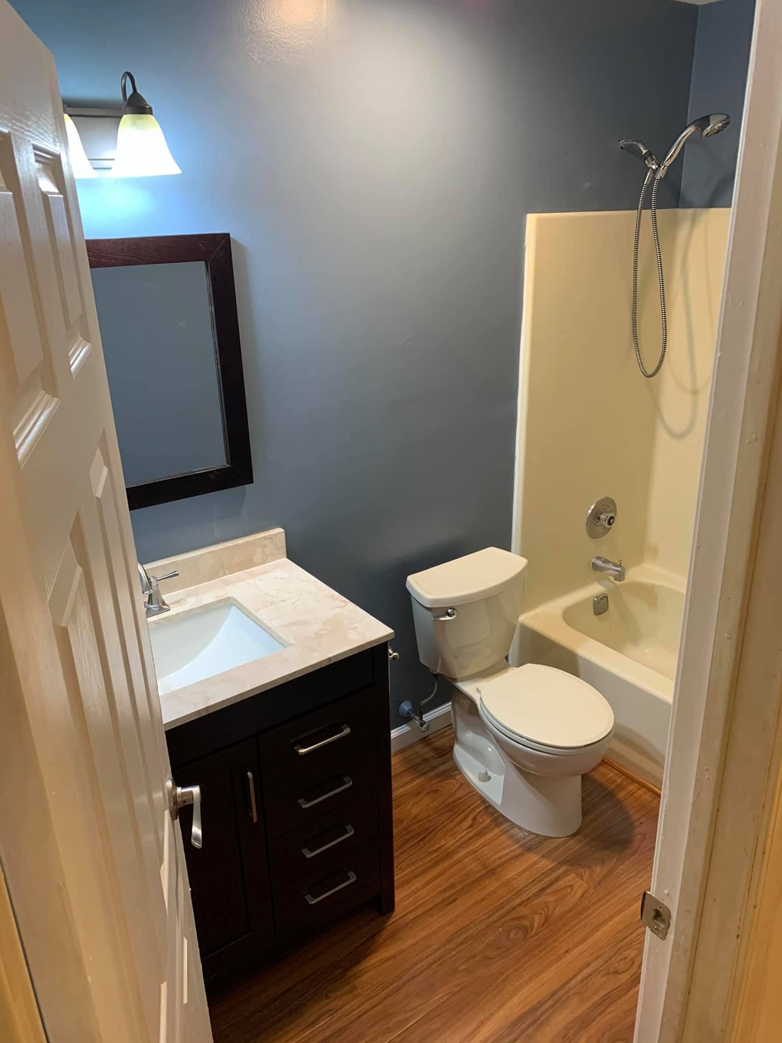 A bathroom with a toilet , sink , and bathtub.