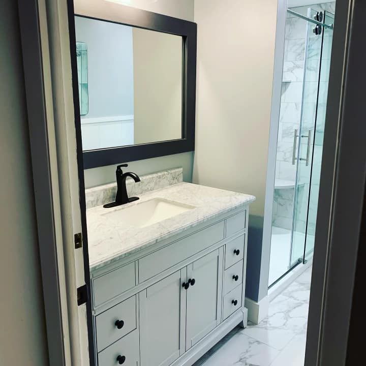 A bathroom with a sink , mirror and shower.