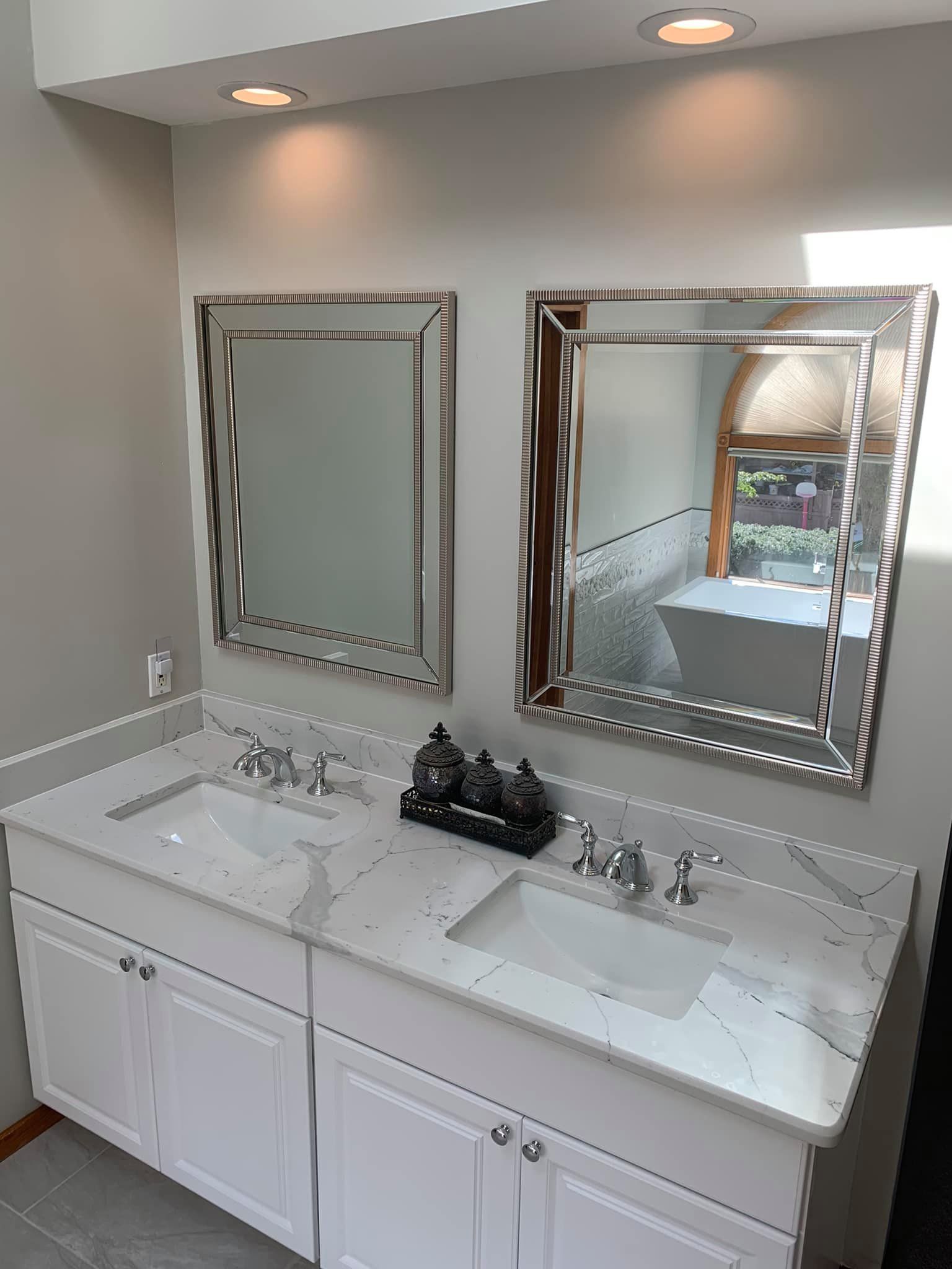 A bathroom with two sinks and two mirrors.