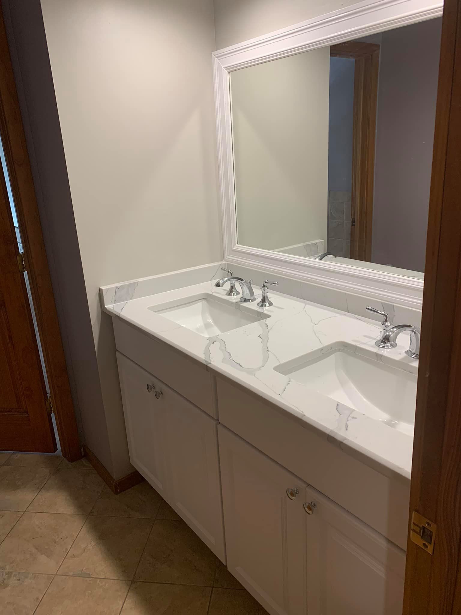 A bathroom with two sinks and a large mirror.