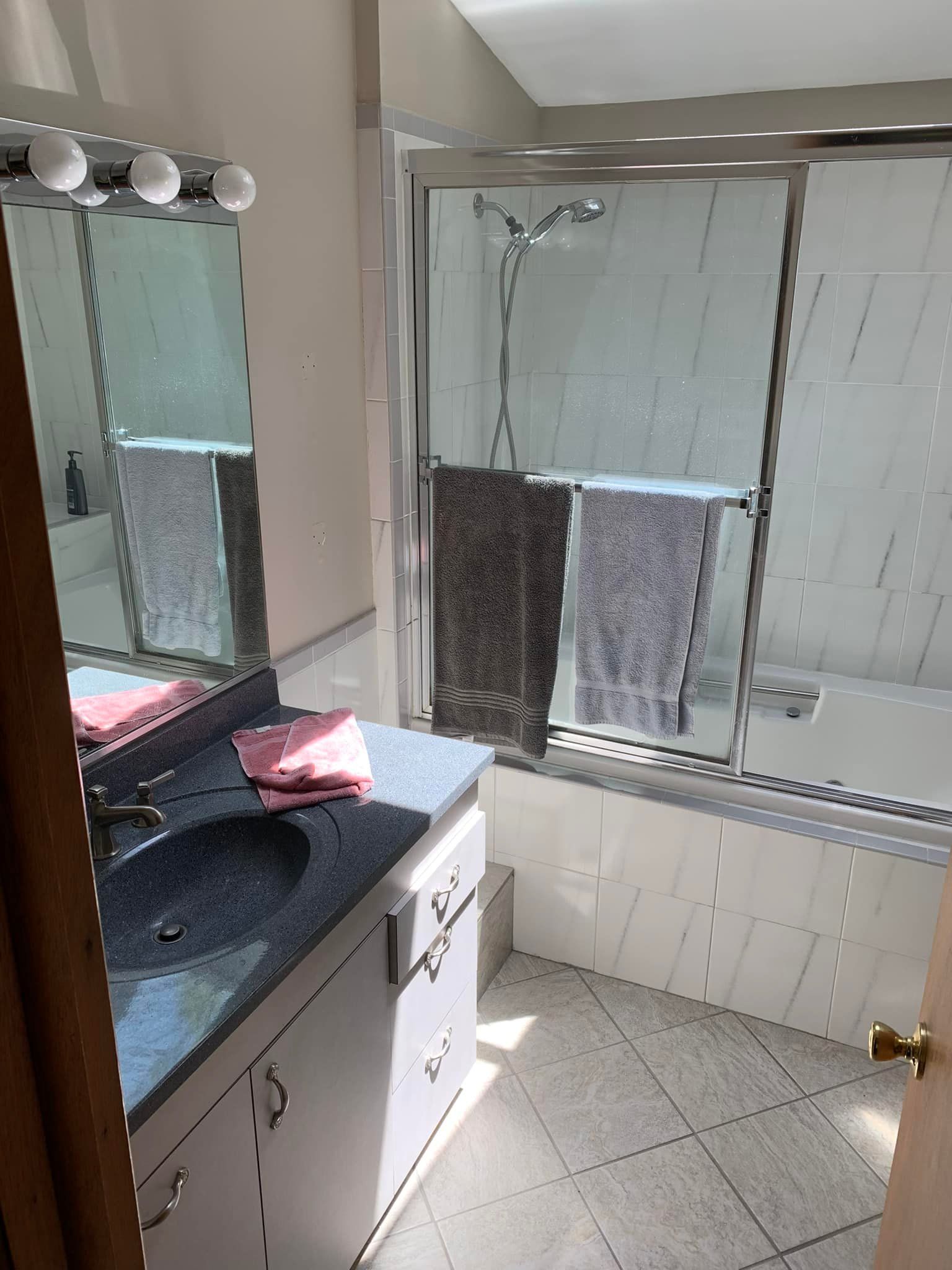 A bathroom with a sink , shower , and bathtub.