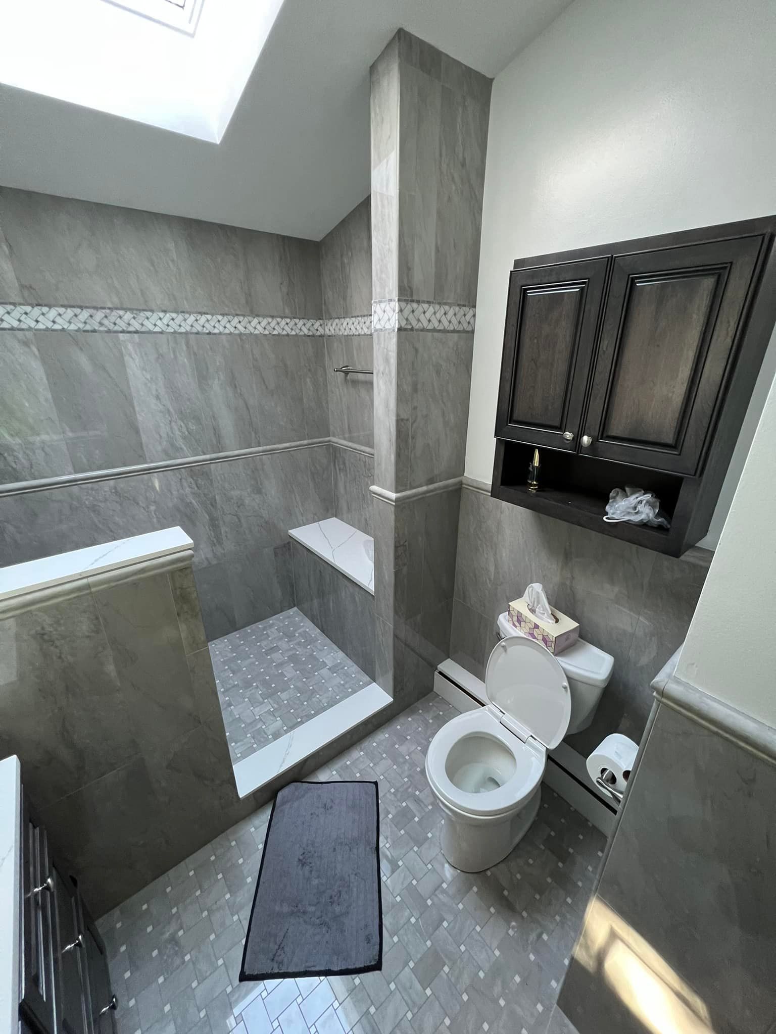 A bathroom with a toilet , shower and sink.