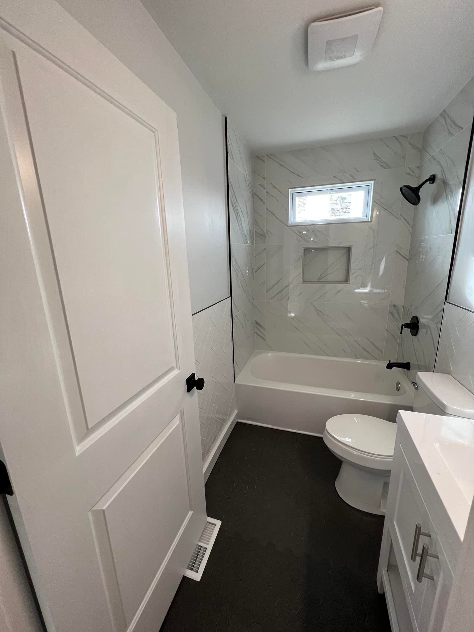 A bathroom with a toilet , sink , tub and shower.