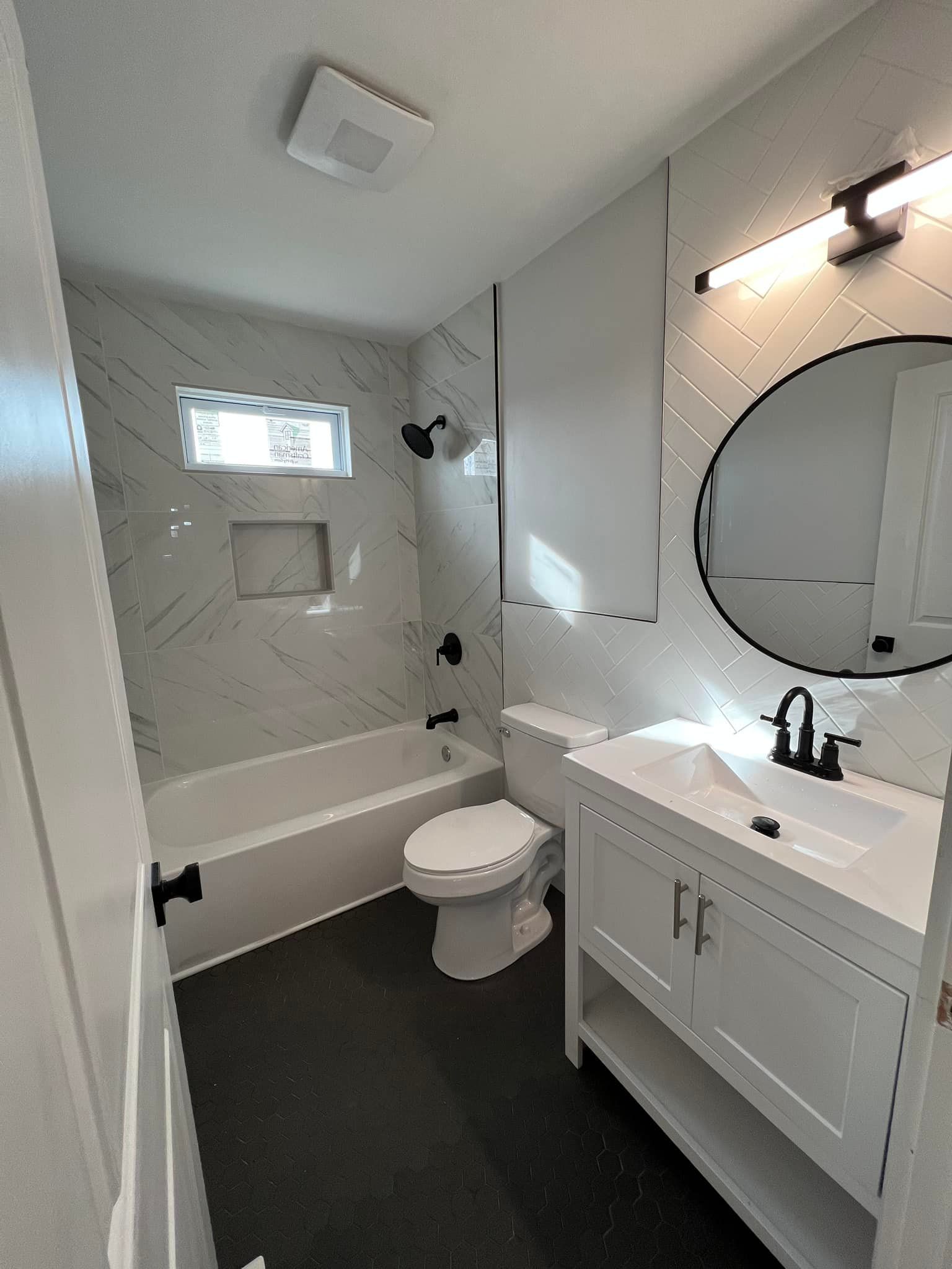A bathroom with a toilet , sink , bathtub and mirror.