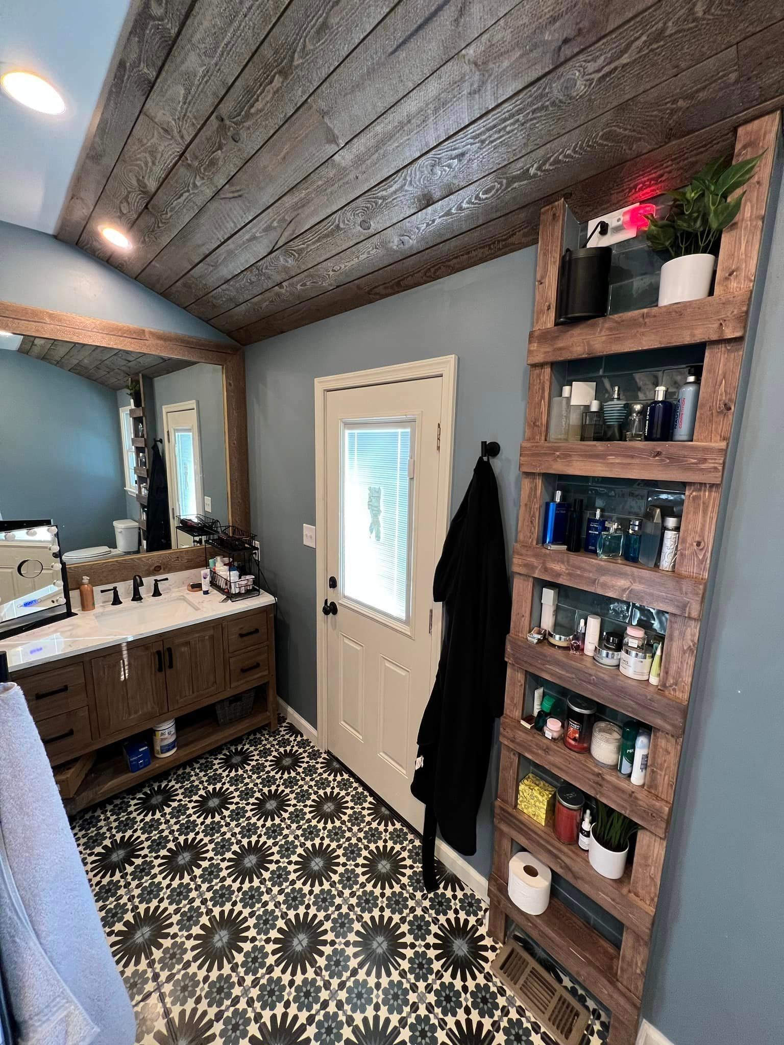 A bathroom with two sinks , a mirror , and a wooden shelf.