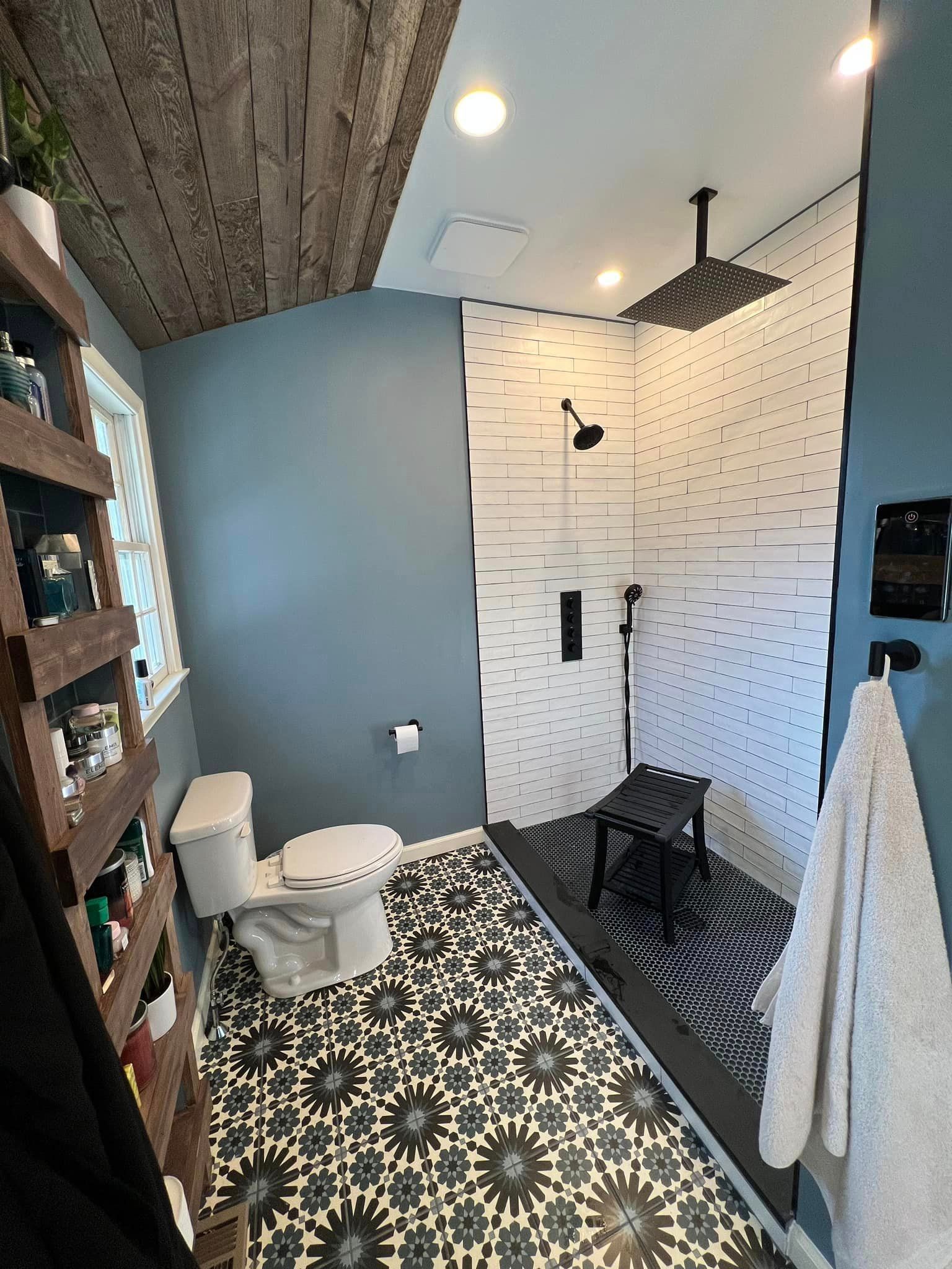 A bathroom with a toilet and a walk in shower.