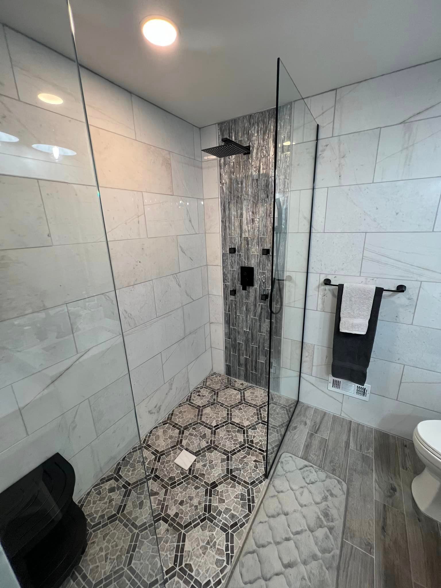 A bathroom with a walk in shower and a toilet.