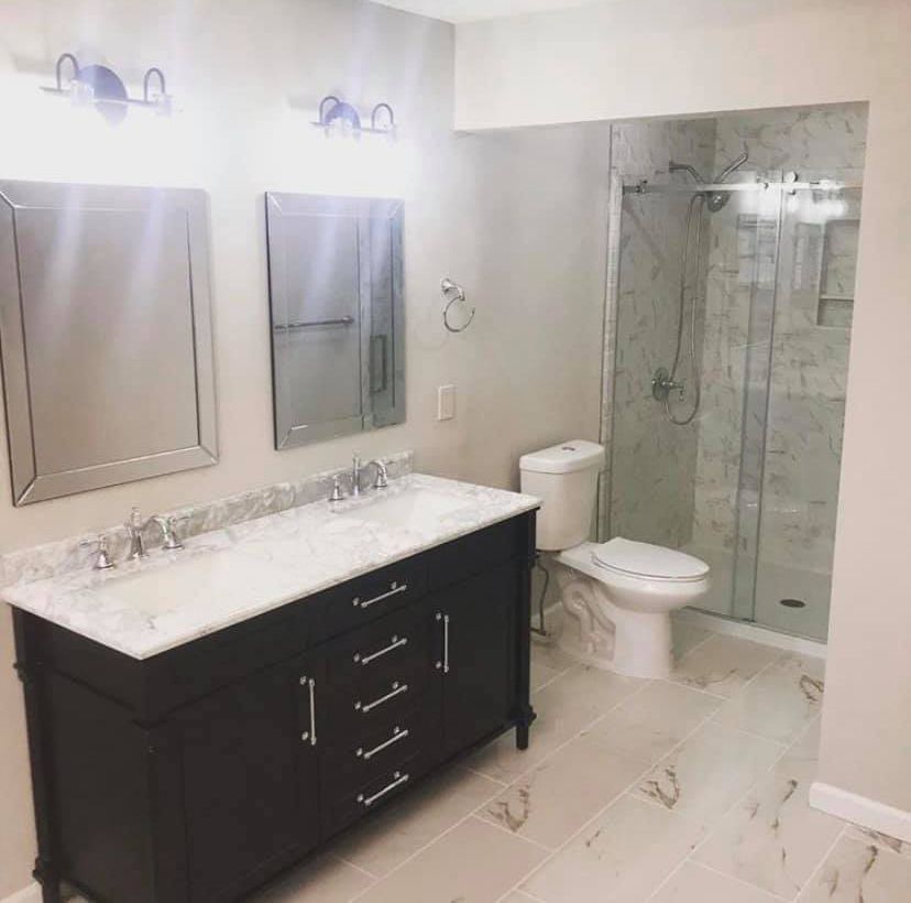 A bathroom with a toilet , sink and mirrors