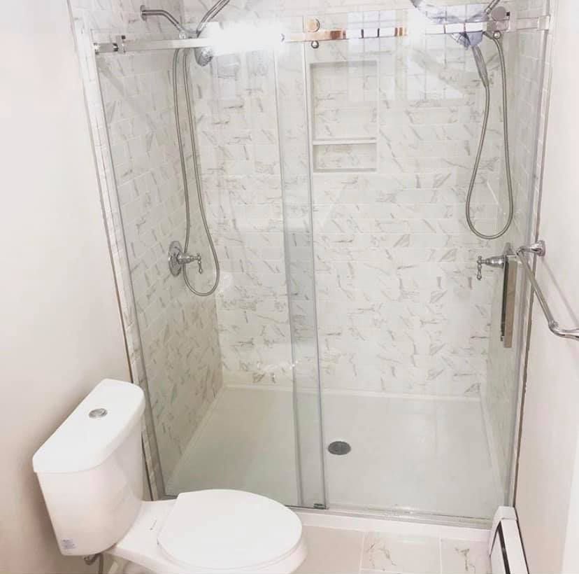 A bathroom with a toilet and a shower with a glass door