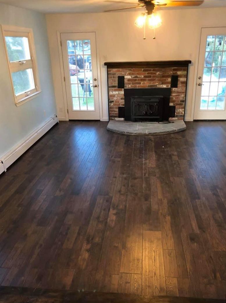 A living room with hardwood floors and a fireplace.