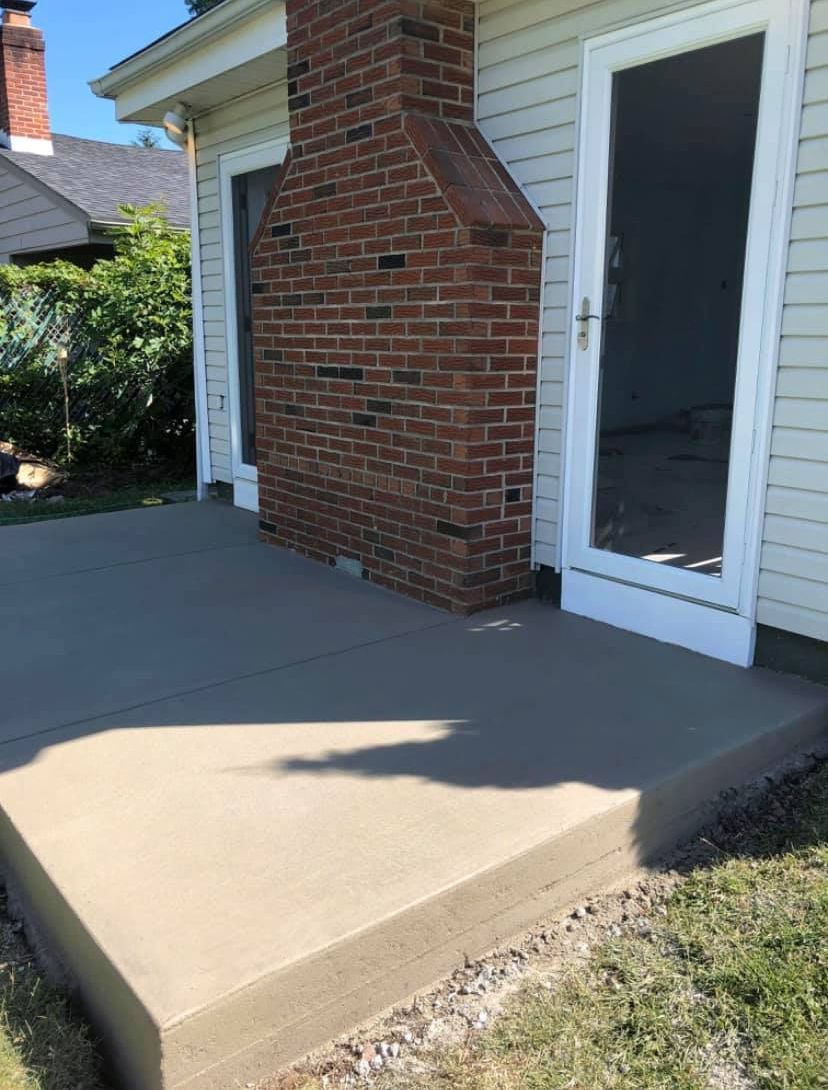 There is a brick fireplace in the backyard of a house.