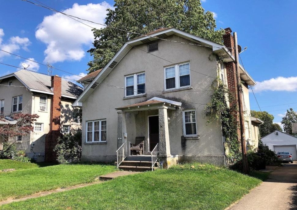 A large white house with a porch and stairs