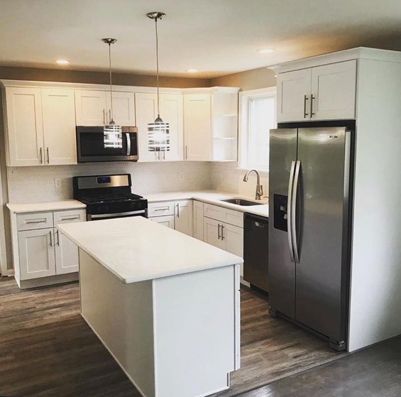 A kitchen with stainless steel appliances and white cabinets