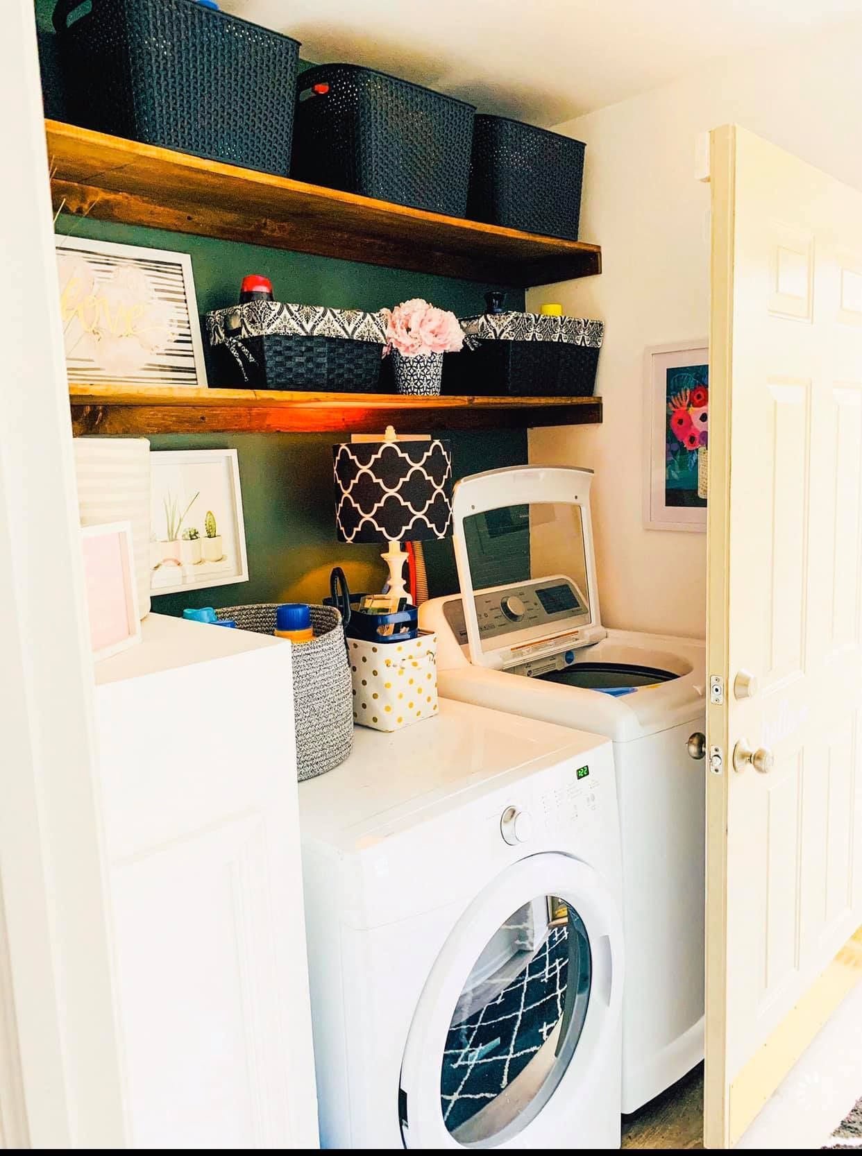 A laundry room with a washer and dryer and shelves.
