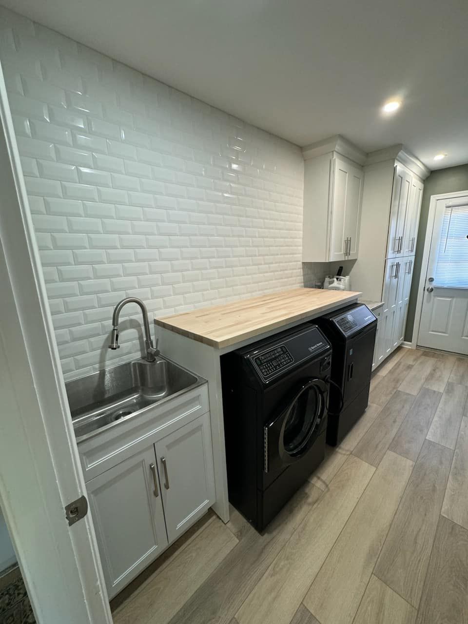 A laundry room with a sink , washing machine , and dryer.