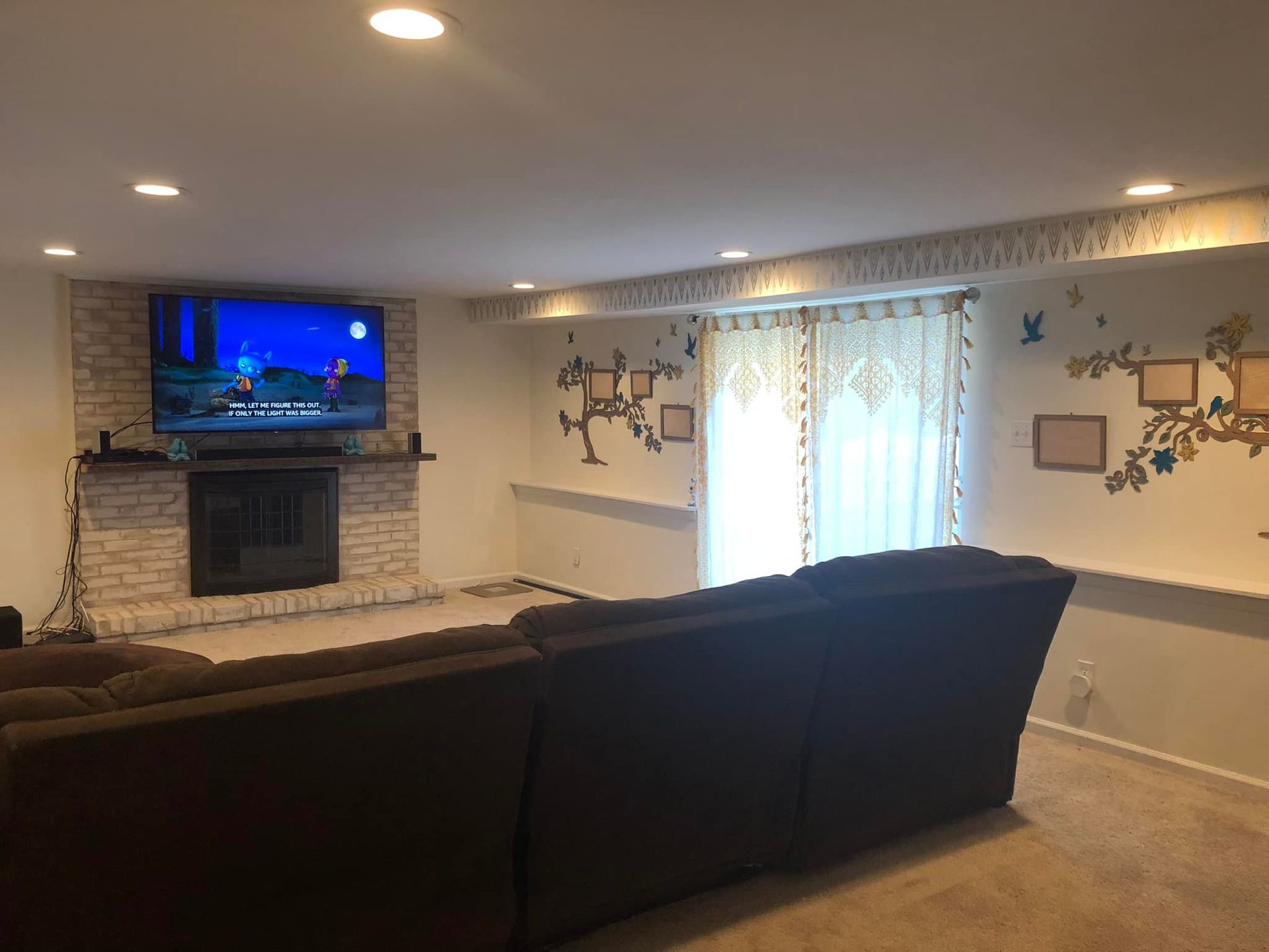 A living room with a couch , fireplace and television.
