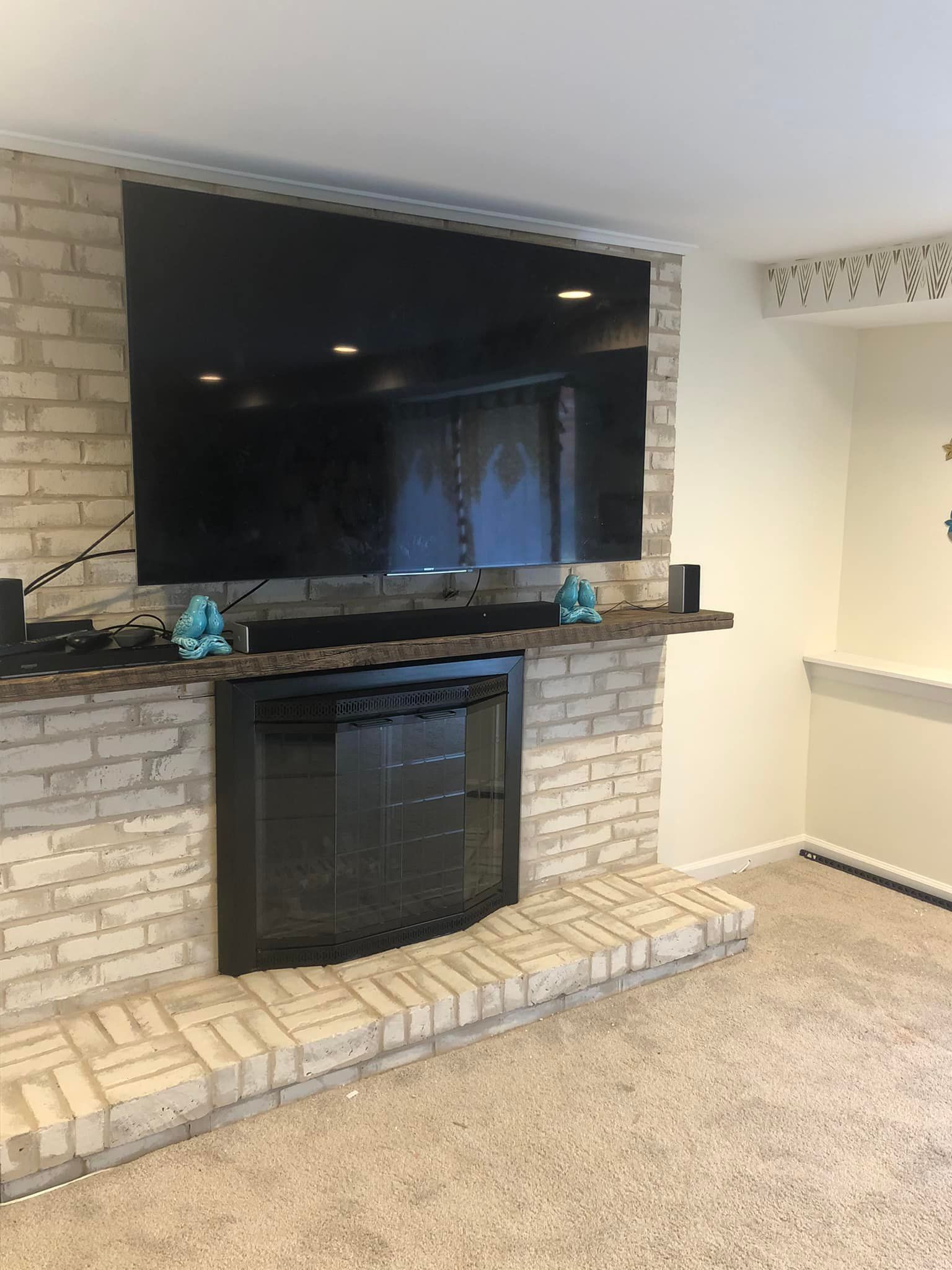 A living room with a fireplace and a flat screen tv